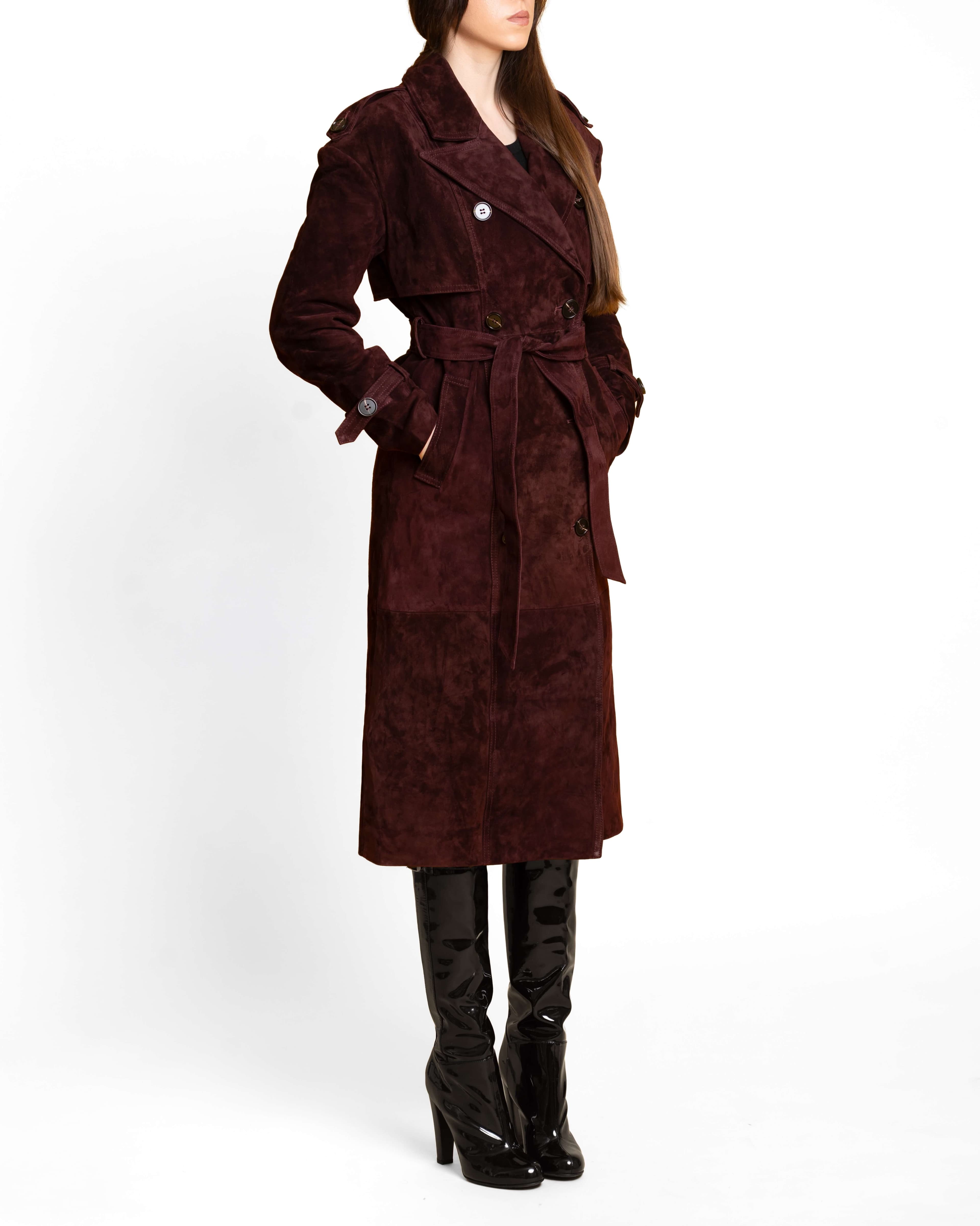 Model wearing a brown suede trench coat in natural daylight